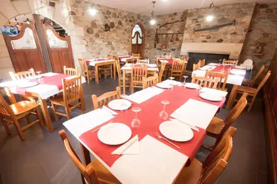 a dining room with tables and chairs with red and white plates at As Viñas in Viveiro