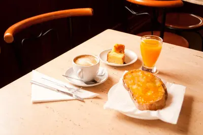 a table with a breakfast of bread and orange juice at As Viñas in Viveiro