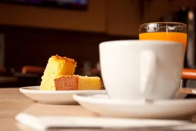 a cup of coffee and a piece of cake on a table at As Viñas in Viveiro