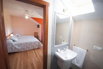 a bathroom with a bed and a sink and a mirror at As Viñas in Viveiro