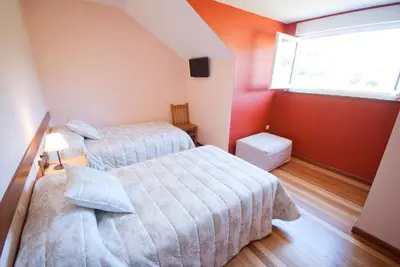 a bedroom with two beds and a window at As Viñas in Viveiro