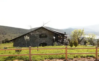 an old stone barn in a field with a fence at Rural Médulas Viviendas de uso turistico 2 y Casas rurales 2 in Las Médulas