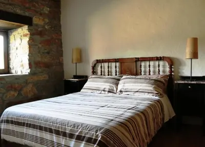 a bed in a bedroom with two lamps on tables at Rural Médulas Viviendas de uso turistico 2 y Casas rurales 2 in Las Médulas