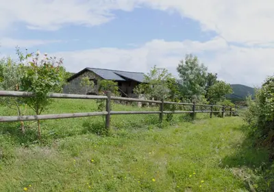 a wooden fence in a field next to a house at Rural Médulas Viviendas de uso turistico 2 y Casas rurales 2 in Las Médulas
