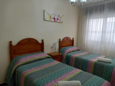 a bedroom with two beds and a window at Albergue Agarimo in Caldas de Reis