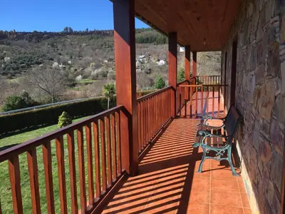 a balcony of a house with a bench at Alojamiento en entorno rural Los Trobos in Villar de Otero