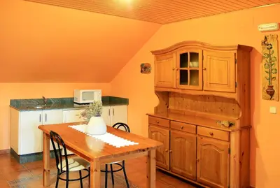 a kitchen with a wooden table and a wooden cabinet at Alojamiento en entorno rural Los Trobos in Villar de Otero