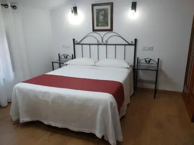 a bedroom with a large bed with white and red sheets at LAST 12K in Santiago de Compostela