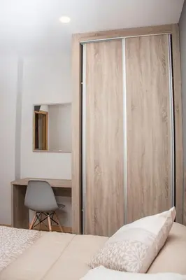 a bedroom with a sliding closet door with a desk at O Vendaval Hostal Restaurante in Barreiros