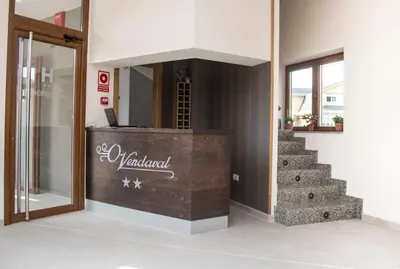 a room with a counter with a staircase and a mirror at O Vendaval Hostal Restaurante in Barreiros