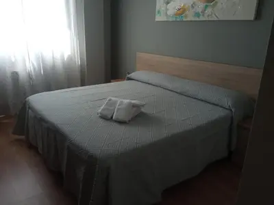 a bedroom with a bed with a white pillow on it at O Vendaval Hostal Restaurante in Barreiros
