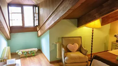 a bedroom with a chair and a lamp and a bed at Hotel Valle del Silencio in Ponferrada