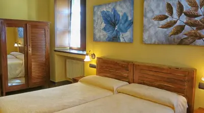 a bedroom with two beds and a mirror at Hotel Valle del Silencio in Ponferrada