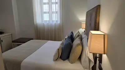 a bedroom with a large bed with blue pillows at VISTALEGRE Hotel-Spa in Portomarin