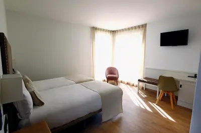 a hotel room with a bed and a window at VISTALEGRE Hotel-Spa in Portomarin