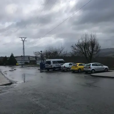 a group of cars parked in a parking lot at Pensión Portomiño in Portomarin