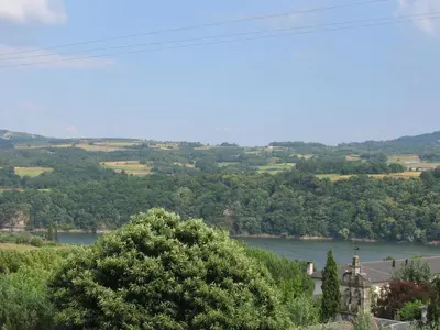 a view of a river with a house and trees at Pensión Portomiño in Portomarin