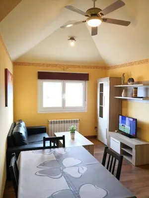 a living room with a table and a couch at Apartamento Apega in Ribadeo