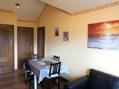 a dining room with a table and a couch at Apartamento Apega in Ribadeo