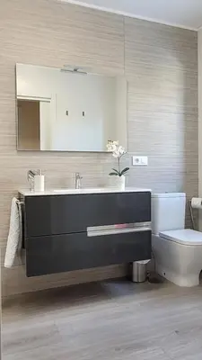 a bathroom with a sink and a toilet and a mirror at Besbello Suites - Apartamento in Santiago de Compostela