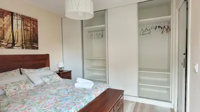 a bedroom with a bed and walk in closet at Besbello Suites - Apartamento in Santiago de Compostela