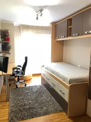 a bedroom with a bed and a desk and a chair at El piso de Carlos in Ribadeo