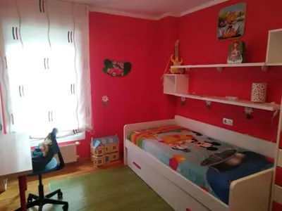 a bedroom with red walls and a bed and a desk at El piso de Carlos in Ribadeo
