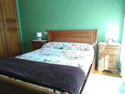 a bedroom with a bed and a blue wall at El piso de Carlos in Ribadeo