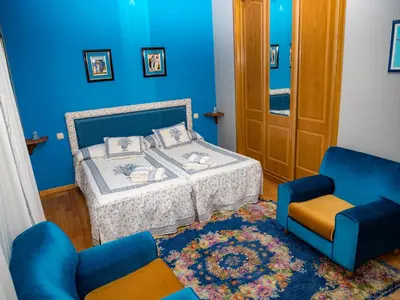 a blue bedroom with a bed and a chair at Casa rural quiroga in Portela