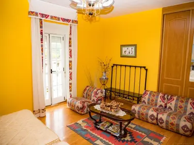 a yellow living room with a couch and a table at Casa rural quiroga in Portela