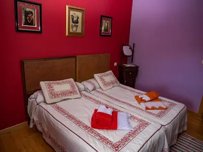 a bedroom with a large bed with red walls at Casa rural quiroga in Portela