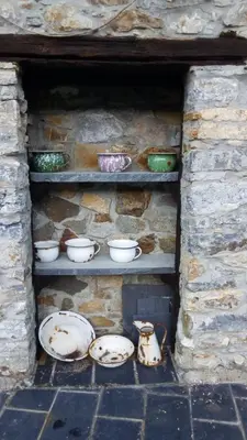 a shelf with bowls and dishes in a stone wall at Casa rural quiroga in Portela
