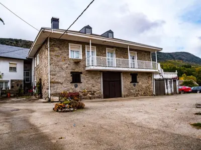 a stone house with a balcony on the side of it at Casa rural quiroga in Portela