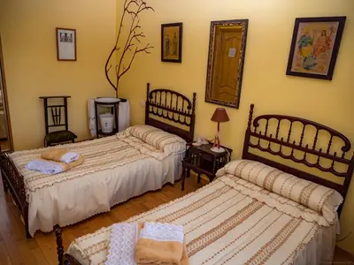 a bedroom with two beds and a table and a mirror at Casa rural quiroga in Portela