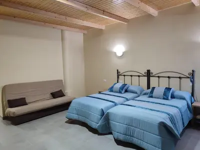 a bedroom with two beds and a couch at Hotel Novo in Ponferrada