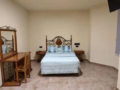 a bedroom with a bed and a dresser and a desk at Hotel Novo in Ponferrada