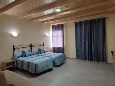 a bedroom with two beds and a window at Hotel Novo in Ponferrada
