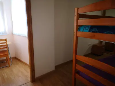 a bedroom with two bunk beds and a table at Duplex Tres Dormitorios Playa A Rapadoira in Foz