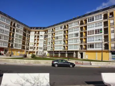 a car parked in front of a large apartment building at Duplex Tres Dormitorios Playa A Rapadoira in Foz