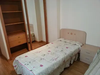 a small bedroom with a bed and a dresser at Duplex Tres Dormitorios Playa A Rapadoira in Foz
