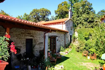 an old stone house with a garden and a church at Pazo de Chaioso Ribeira Sacra in Maceda