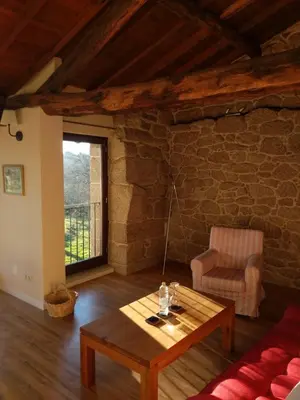 a living room with a table and a chair at Pazo de Chaioso Ribeira Sacra in Maceda