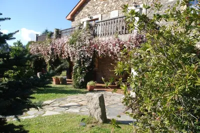 a house with a flowering tree in front of it at Lugar do Sixto in Cordido