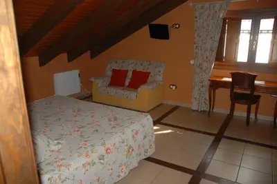 a bedroom with a bed and a chair and a desk at Lugar do Sixto in Cordido