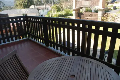 a wooden deck with a bench on a balcony at Lugar do Sixto in Cordido