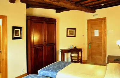 a bedroom with a bed and a wooden cabinet at PR San Nicolás in Santiago de Compostela