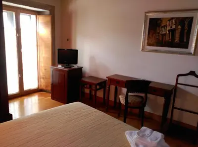 a bedroom with a bed and a desk and a television at PR San Nicolás in Santiago de Compostela