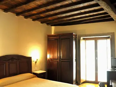 a bedroom with a bed and a dresser and a window at PR San Nicolás in Santiago de Compostela