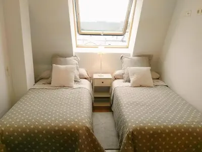 two beds in a small room with a window at San Ciprian Atico Tres Playas by I Love Norte in San Ciprián