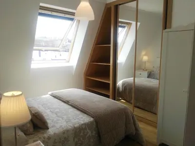 a bedroom with a bed and a window and a mirror at San Ciprian Atico Tres Playas by I Love Norte in San Ciprián